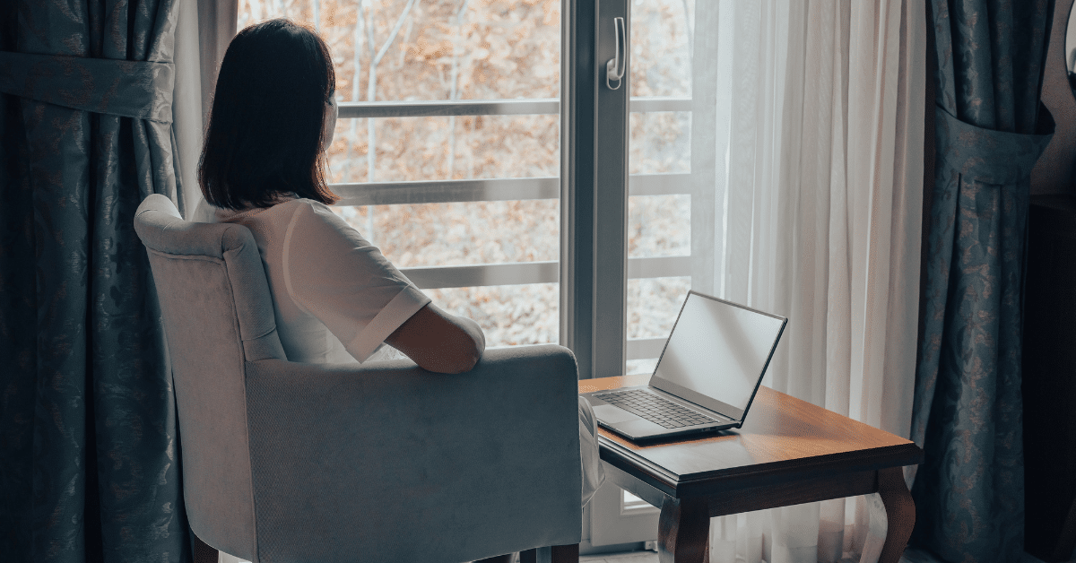 Woman sitting in a chair looking out the window.
