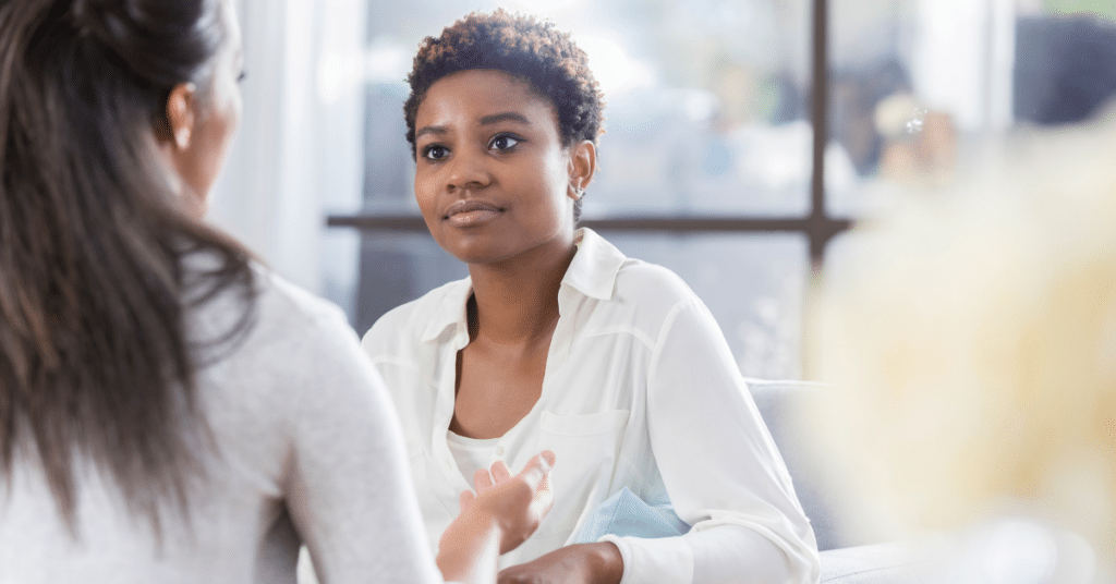 A therapist is intently listening to her client as she speaks